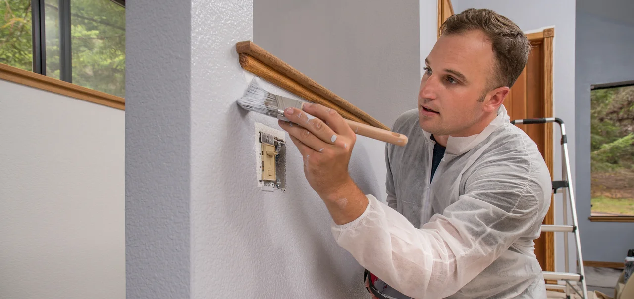 Farben und Malerarbeiten - Professionelle kommerzielle, Anstreicher, Wand Malerei mit Pinsel drinnen im Zimmer des Hauses